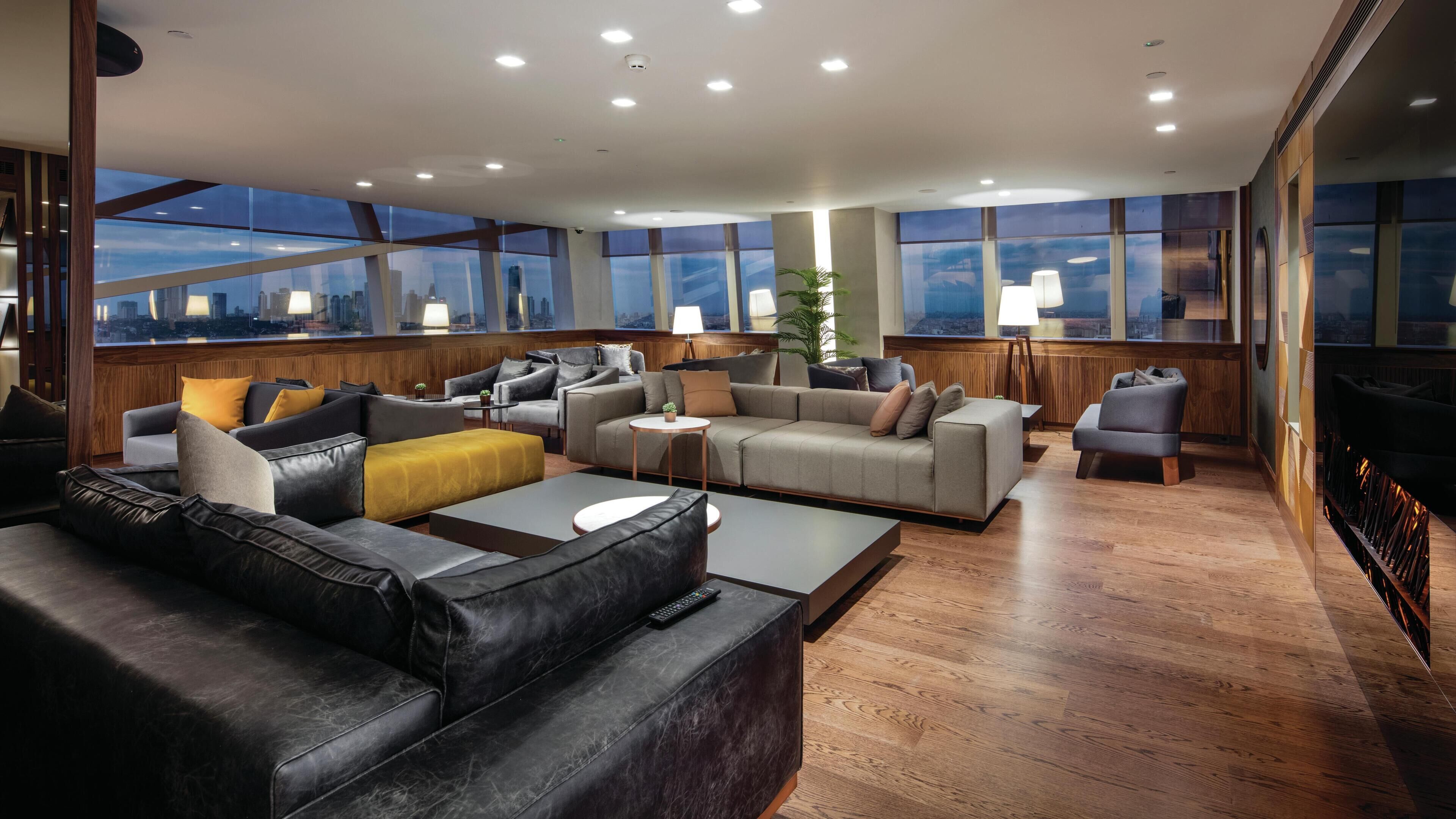 A modern living room with a large sofa, a smaller sofa, a coffee table, and a fireplace.