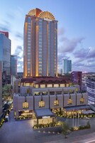 Un hotel con una torre destacada, varias edificaciones y un área de entrada bien iluminada.