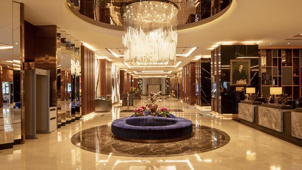 A spacious lobby with a central seating area, a grand chandelier, and a reception desk. - Hilton Istanbul Maslak (Sariyer)