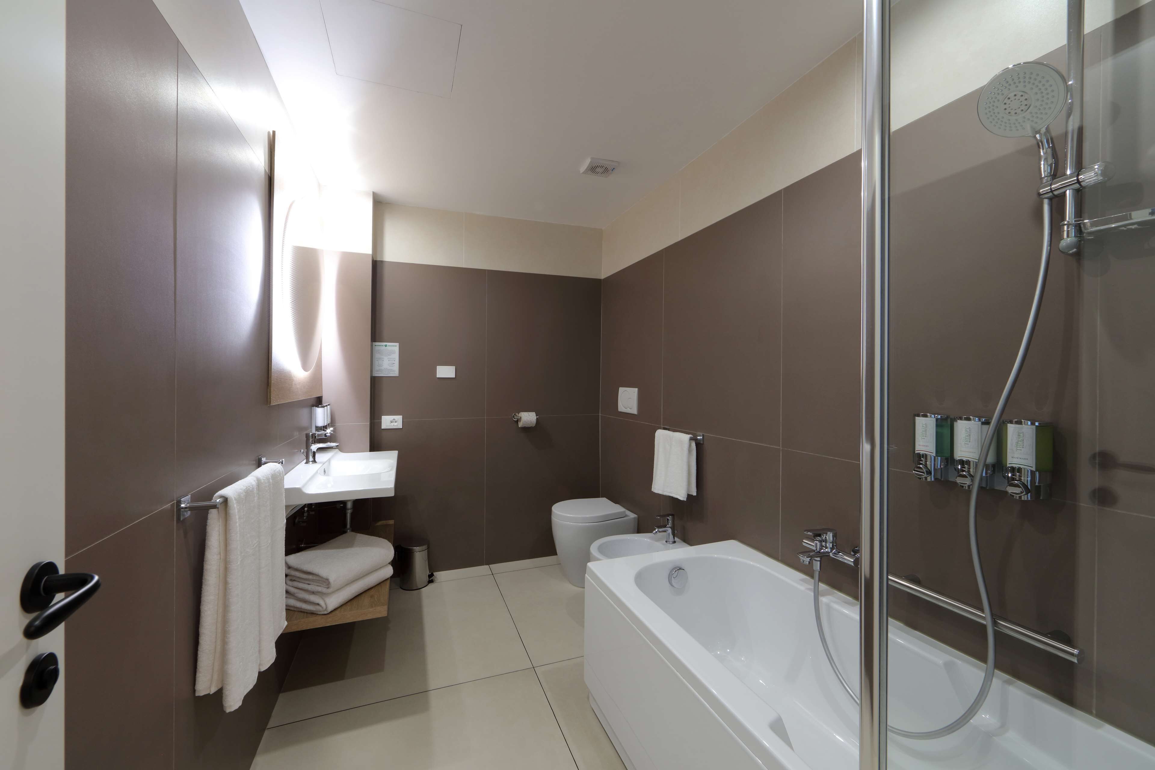 A modern bathroom with a bathtub, toilet, and sink.