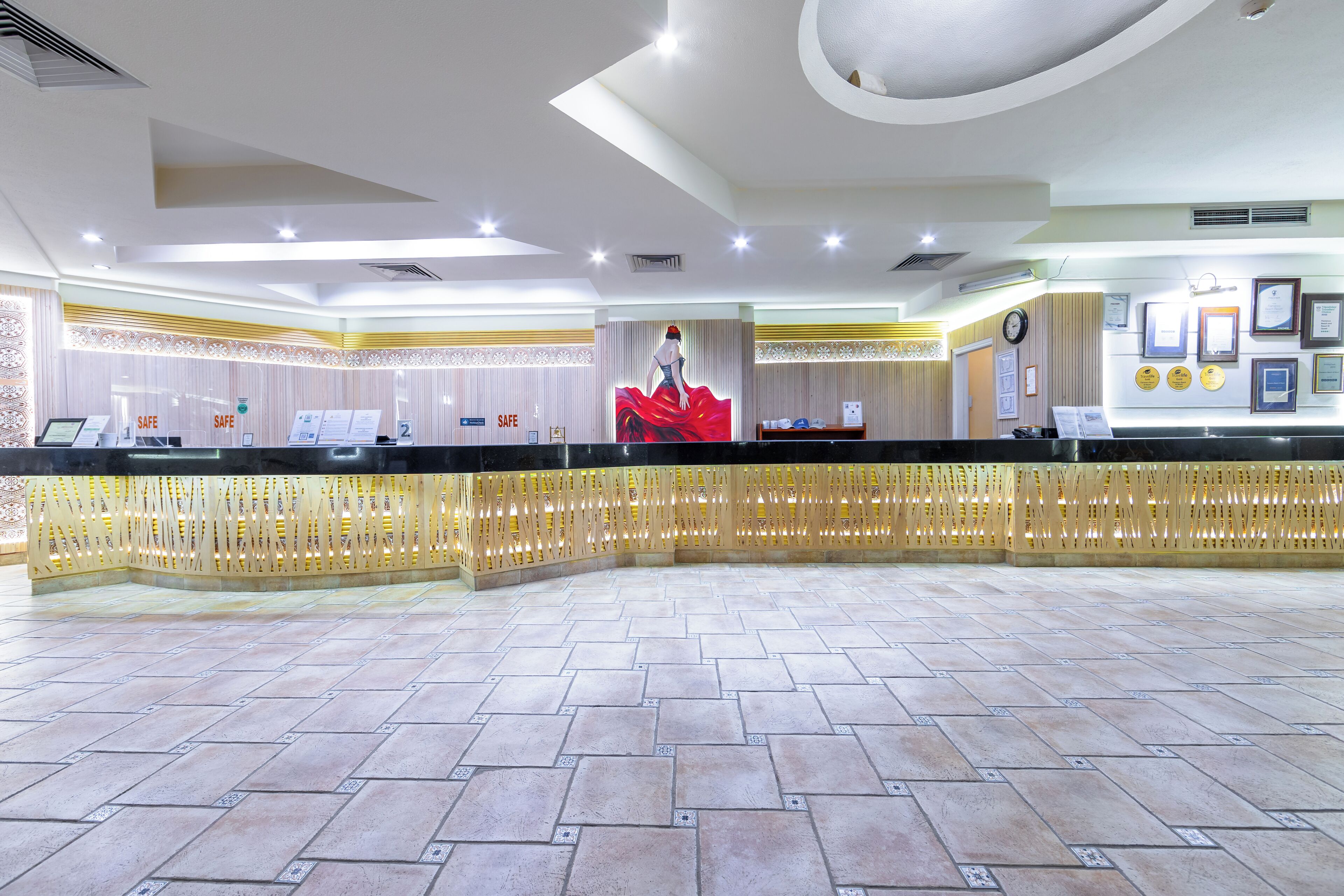 A reception area with a counter, a large clock, and framed certificates on the wall.