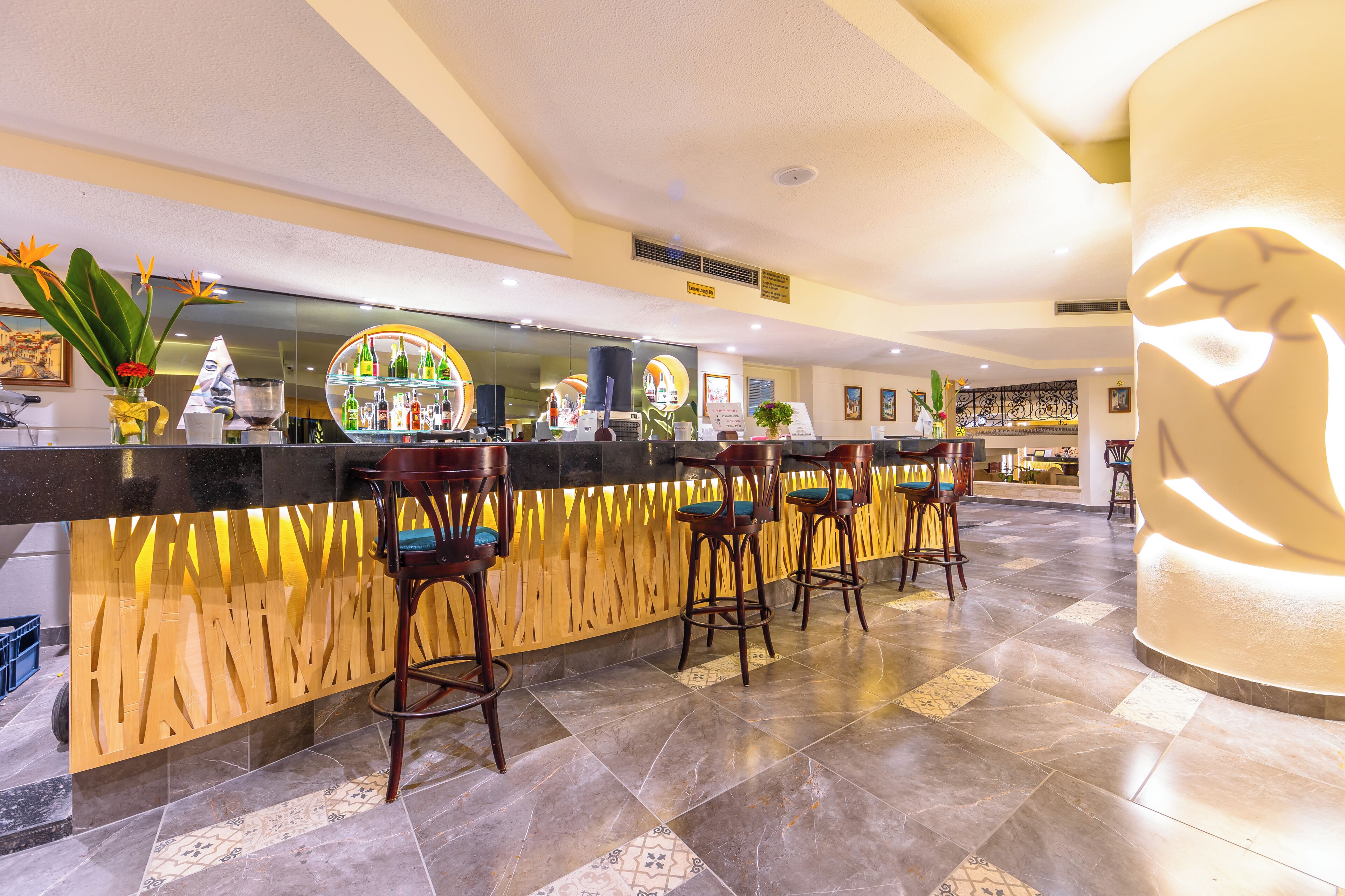Un espace bar avec un comptoir en bois, des tabourets de bar et un sol carrelé.