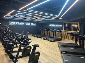 A gym with treadmills, ellipticals, and a wall sign reading 'ONE CLANN - ONE GOAL'. - Pillo Hotel & Leisure Club (Ashbourne)