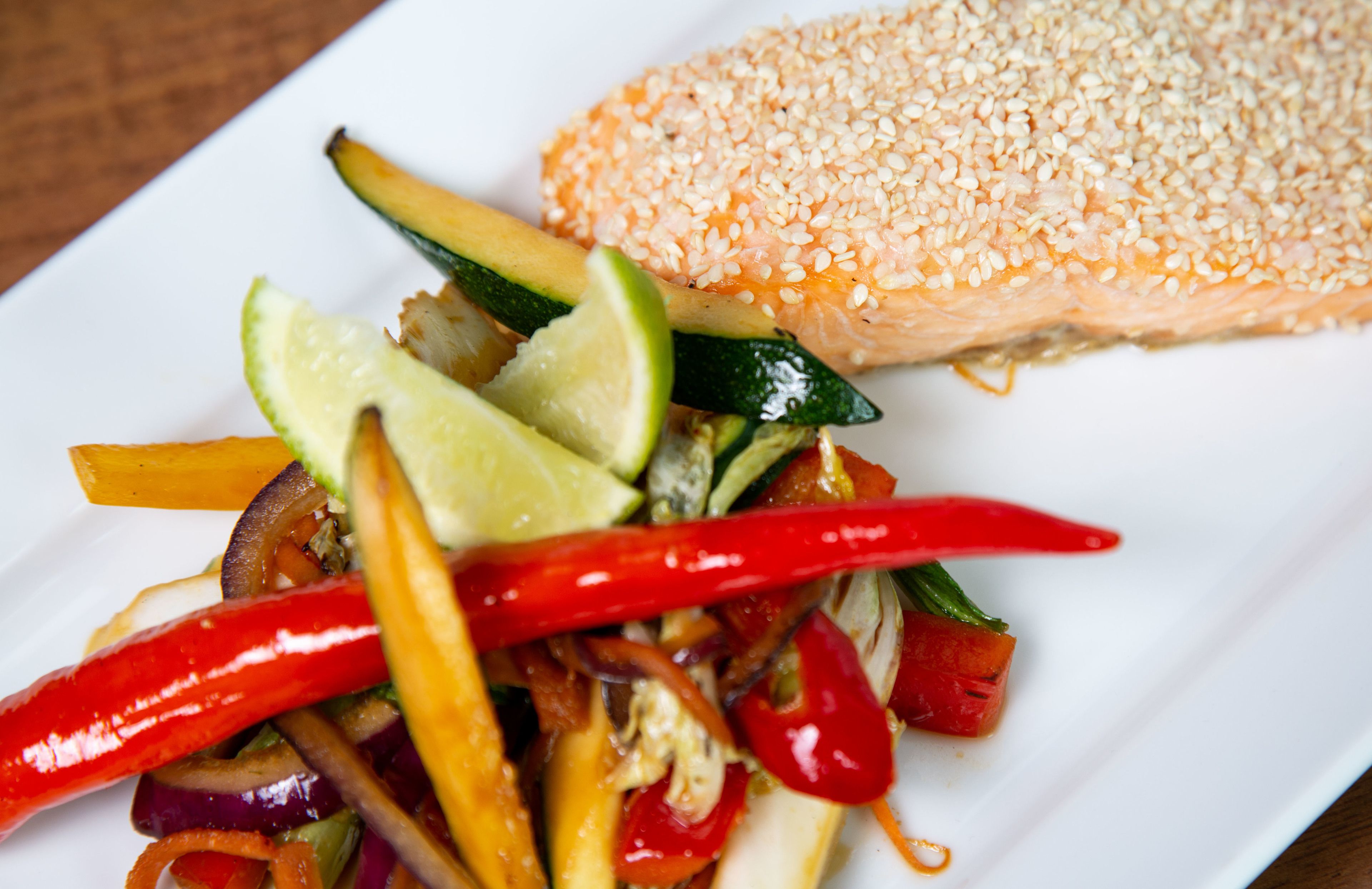A plate with salmon and a vegetable stir-fry.