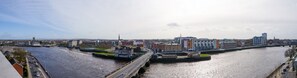 Un paisaje urbano con un río, un puente y una combinación de edificios modernos e históricos.