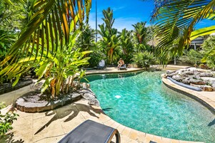 Una piscina al aire libre, sillones reclinables de piscina