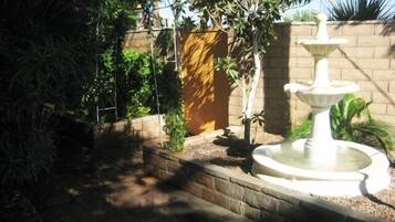 Surrounded by lush greenery, a tranquil fountain creates a serene atmosphere.
