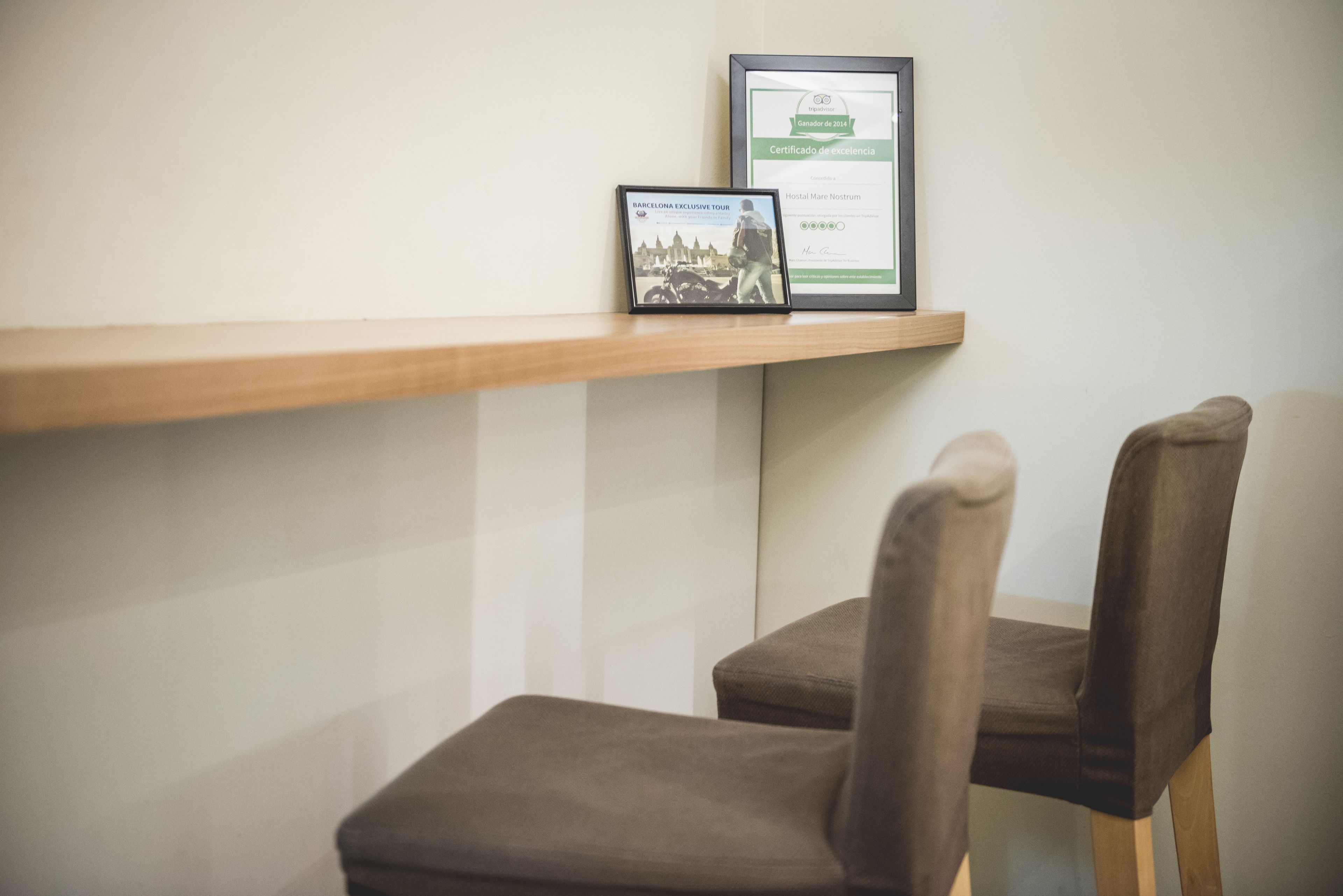 A chair and a shelf with a framed certificate and a CD.