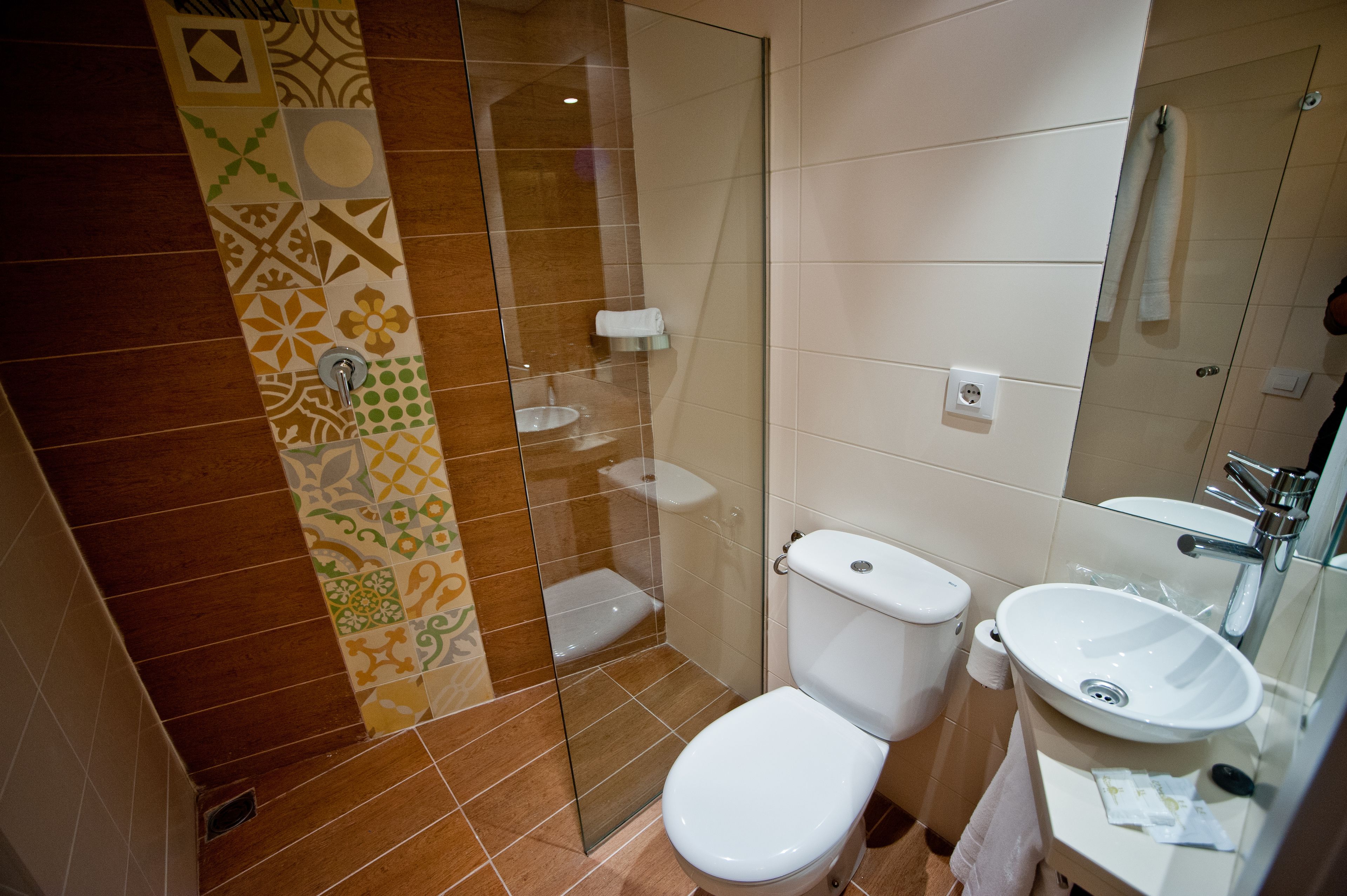 Un baño con inodoro, lavabo y zona de ducha.