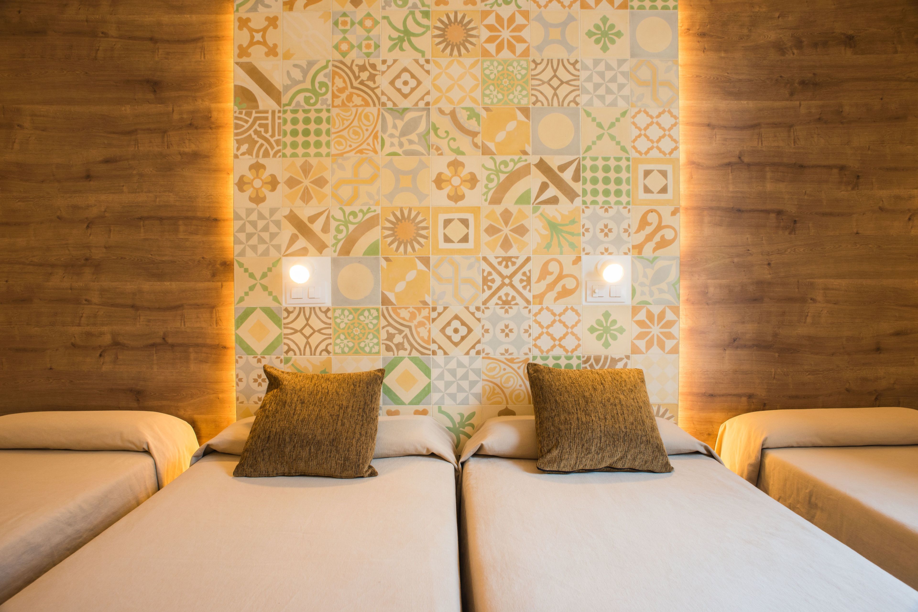 Ein Zimmer mit zwei Betten, einer Wand mit Muster und Holzvertäfelung.