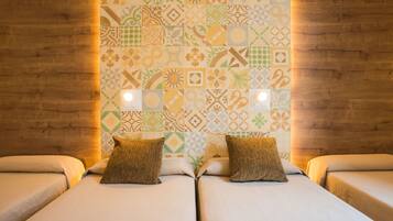 Una habitación con dos camas, un papel tapiz estampado y paneles de madera.