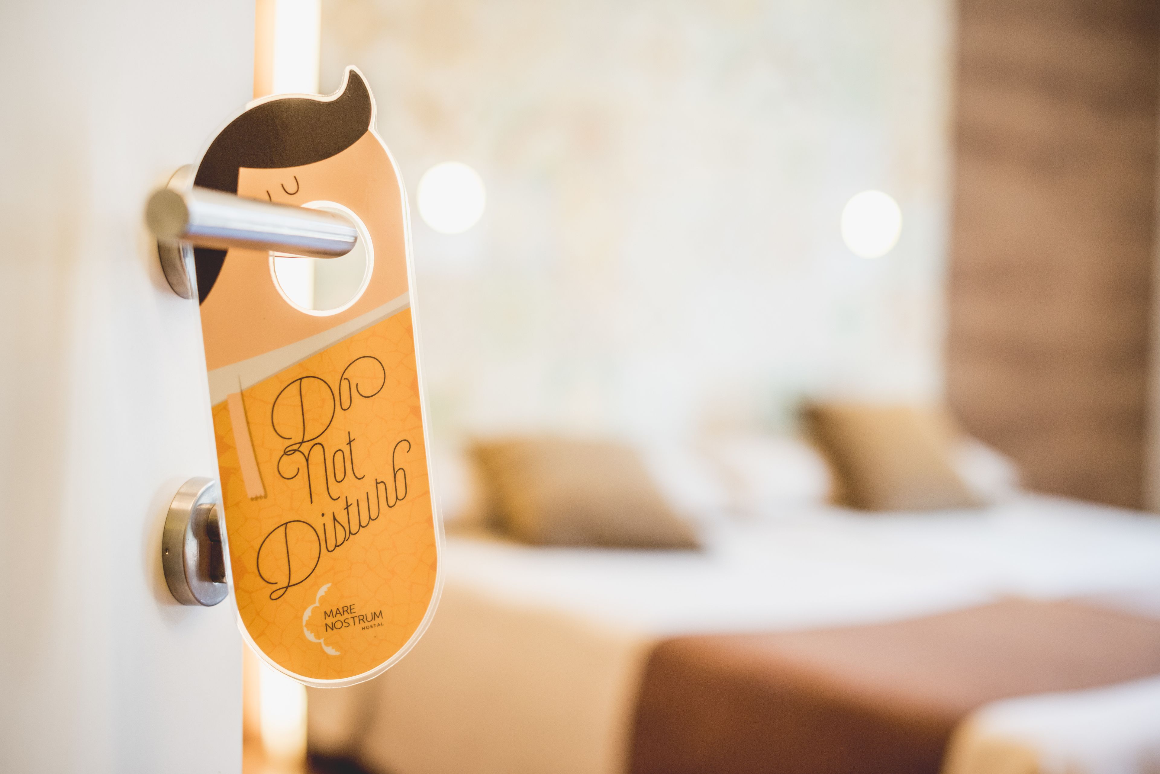 A hotel room door with a sign that reads "Do Not Disturb."