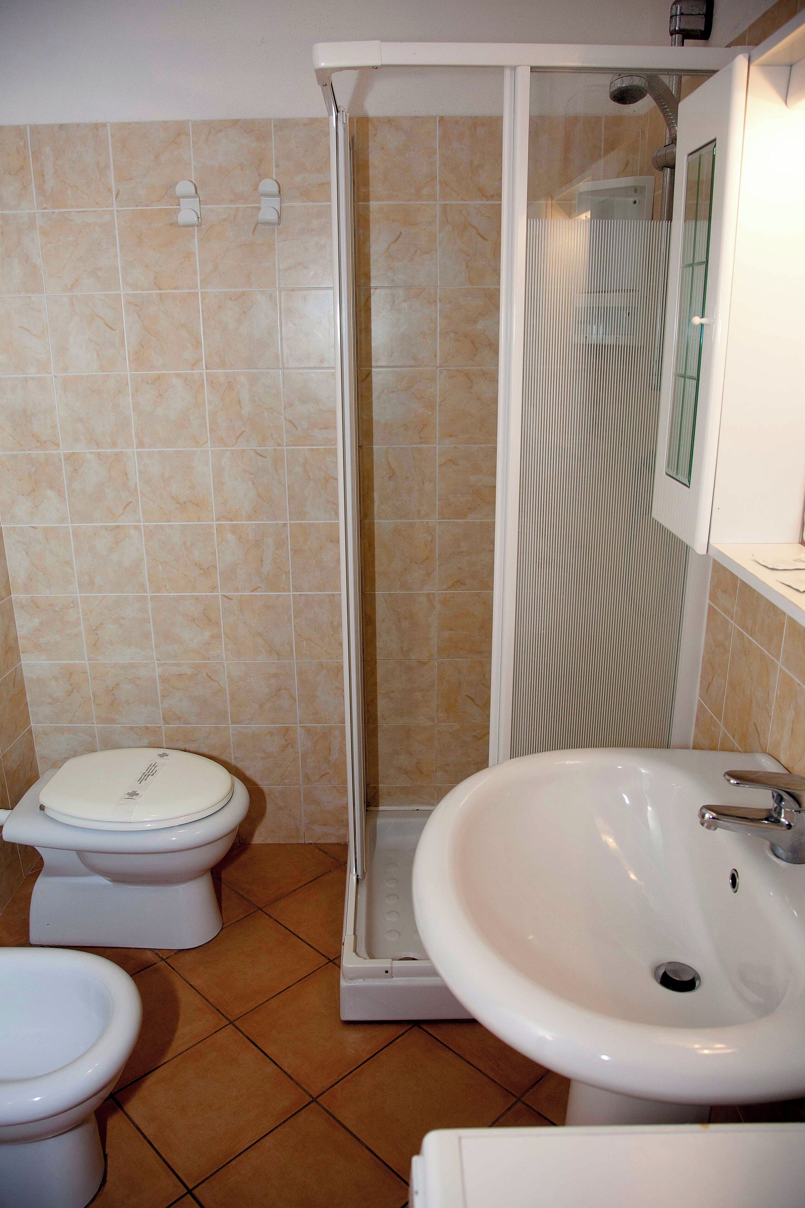 A bathroom with a shower, toilet, and sink.