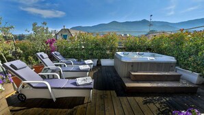 A wooden deck with lounge chairs and a hot tub, surrounded by potted plants and flowers. - Hotel Tigullio et de Milan (Santa Margherita Ligure)