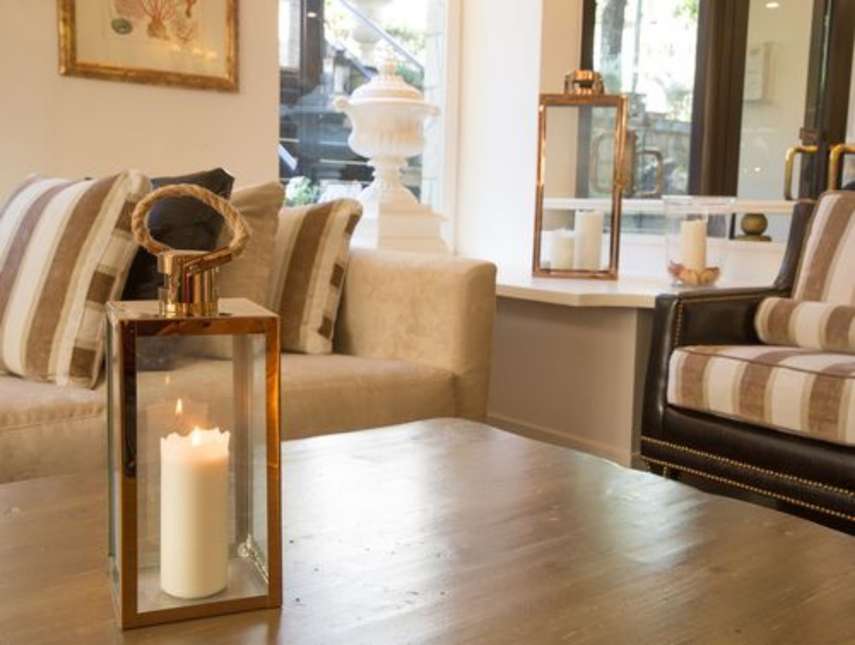 A cozy living room with a sofa, a coffee table, and a decorative mirror.