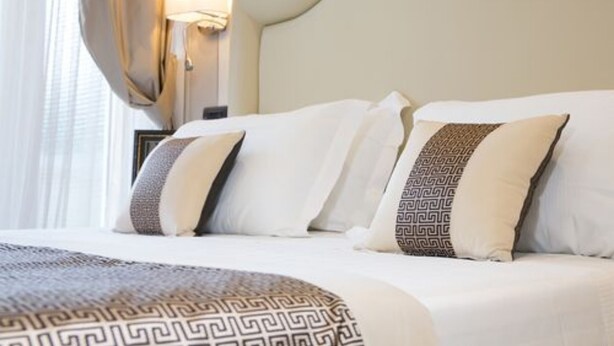 A hotel room with a large bed, white bedding, and patterned pillows. - Hotel Tigullio et de Milan (Santa Margherita Ligure)