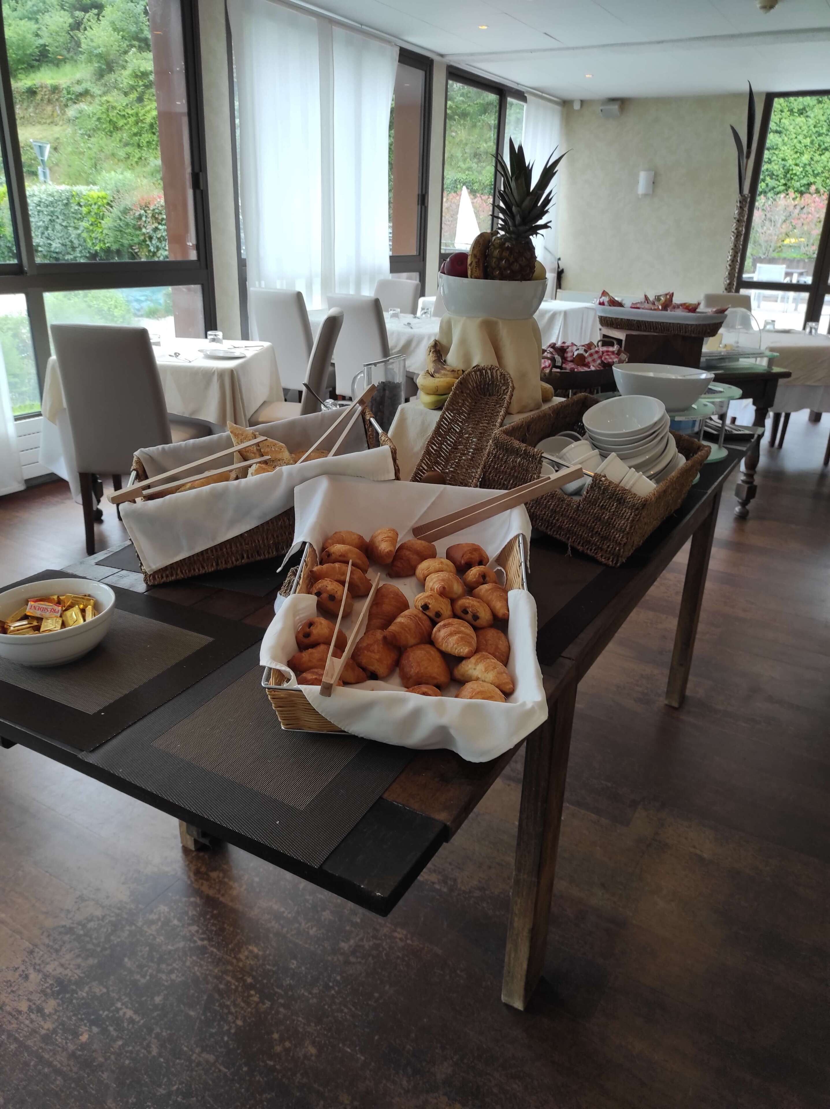 Un bufé con pan, pasteles y frutas.