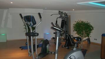 A home gym with exercise equipment including an elliptical, a stationary bike, and a weight machine.