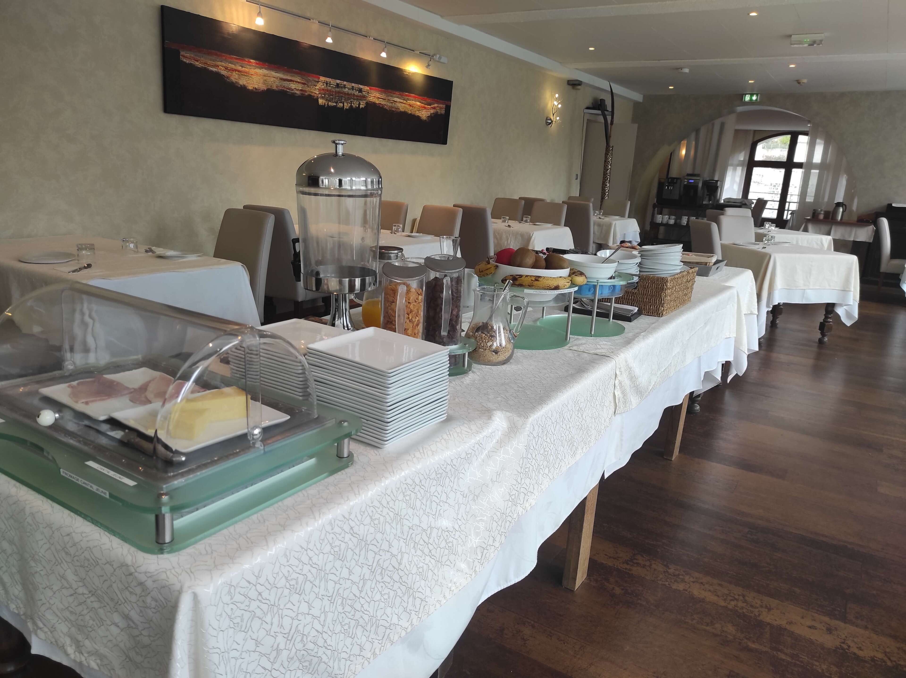 A buffet setup with various food items and a coffee station in a well-lit dining area.