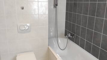 Une salle de bain avec des toilettes, une baignoire et une douche.