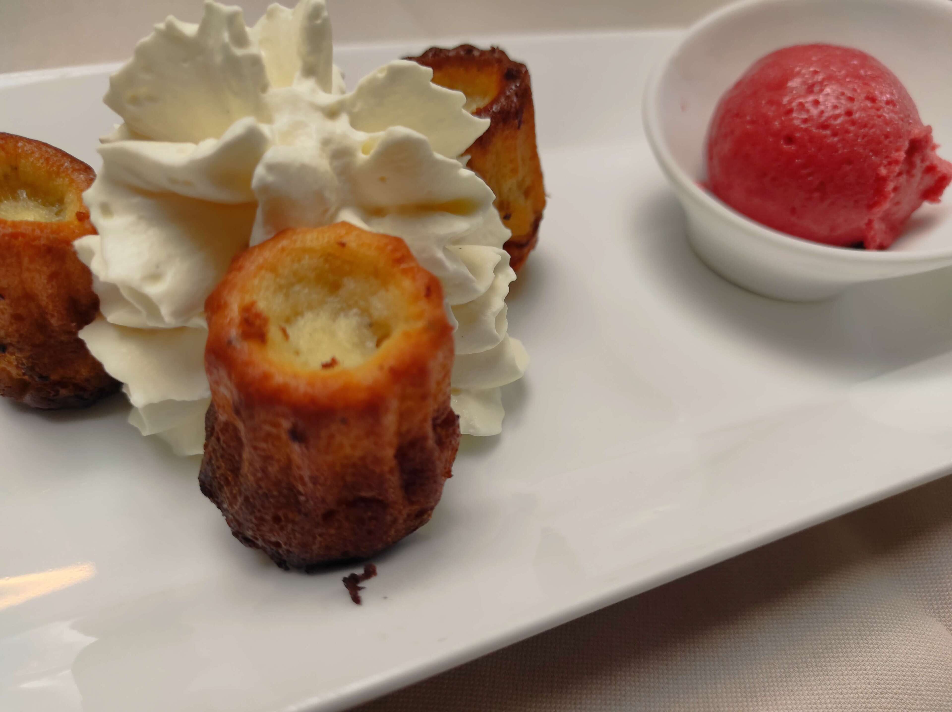 A dessert plate with éclairs and a scoop of ice cream.
