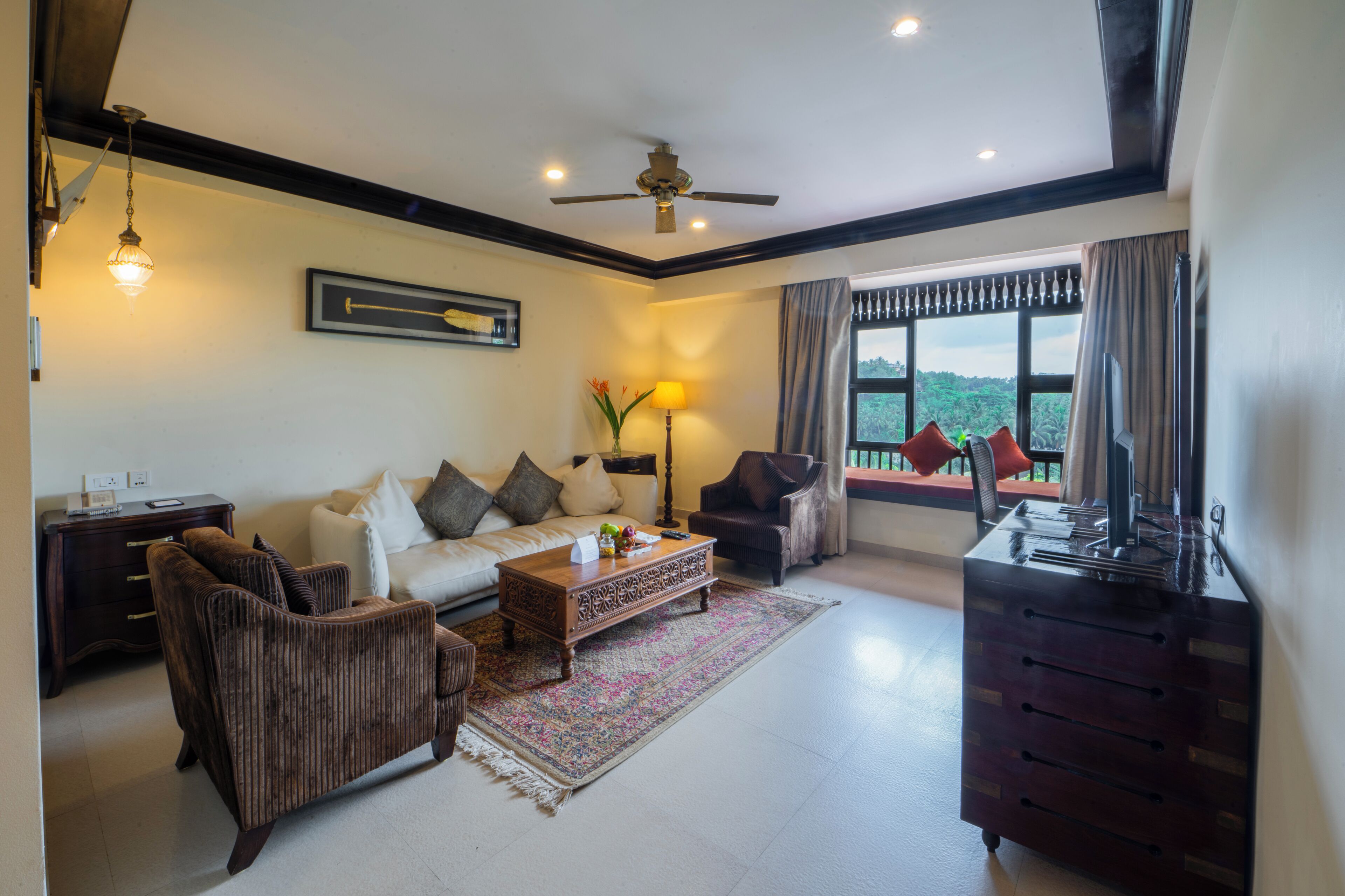 A living room with a sofa, armchairs, a coffee table, and a TV stand.