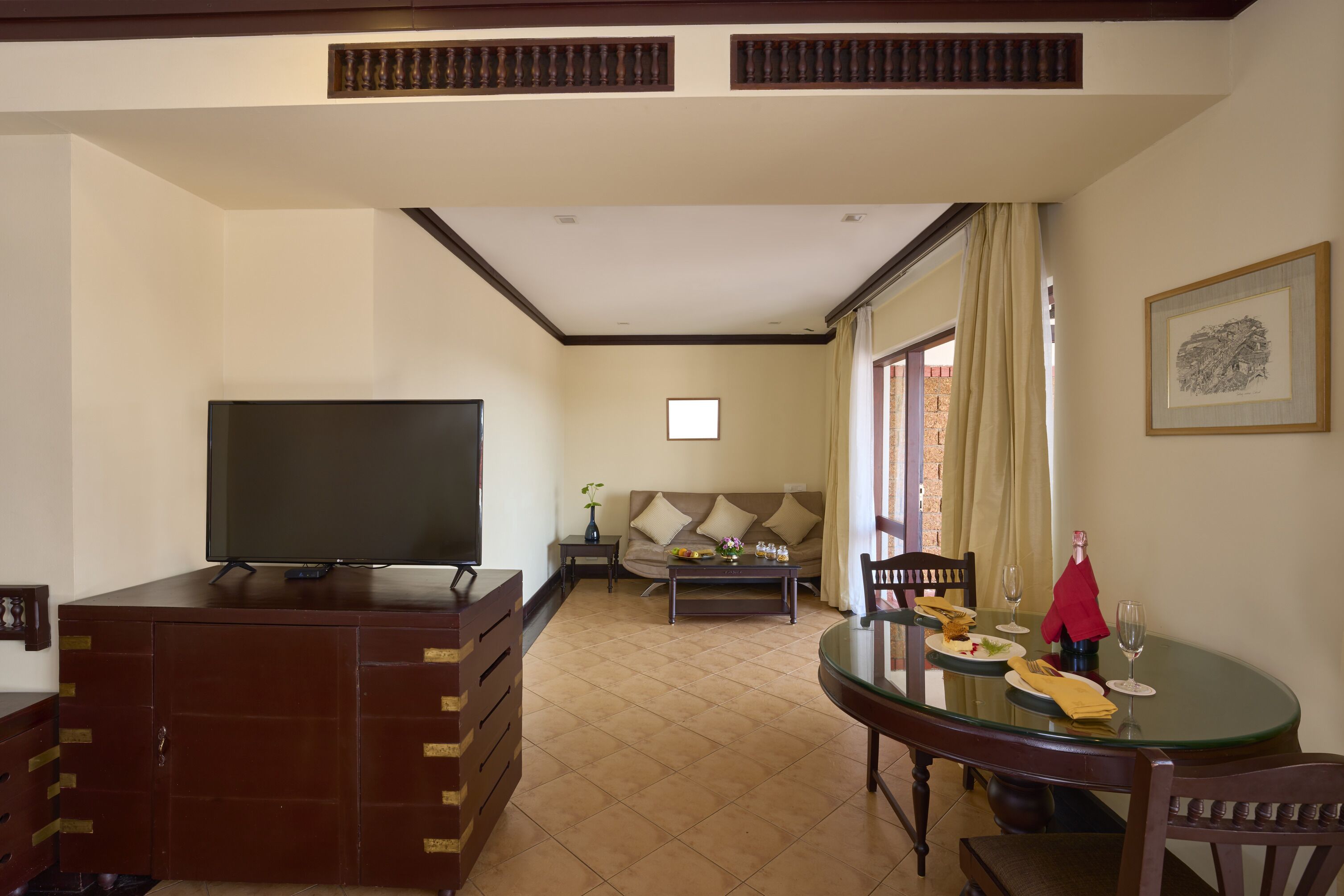 A living room with a TV, sofa, coffee table, and dining table with chairs.