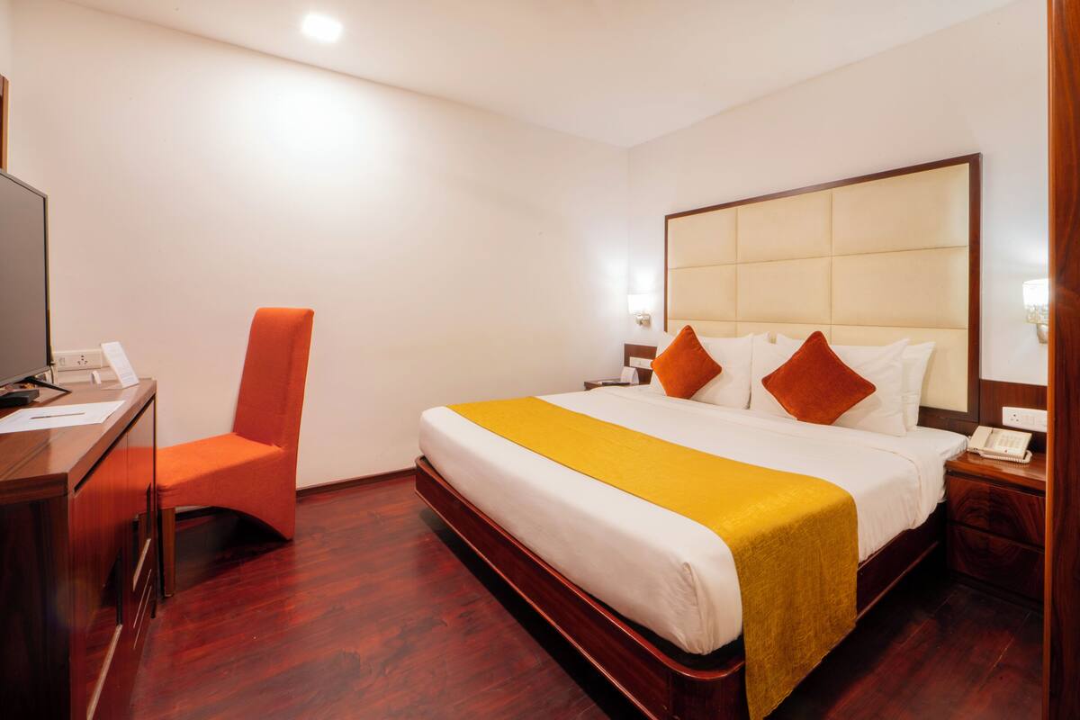 Ein Hotelzimmer mit einem großen Bett, einem Schreibtisch und einem Stuhl.