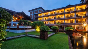 A multi-story hotel with a courtyard and a reflecting pool. - The Raviz Kadavu (Kondotti)