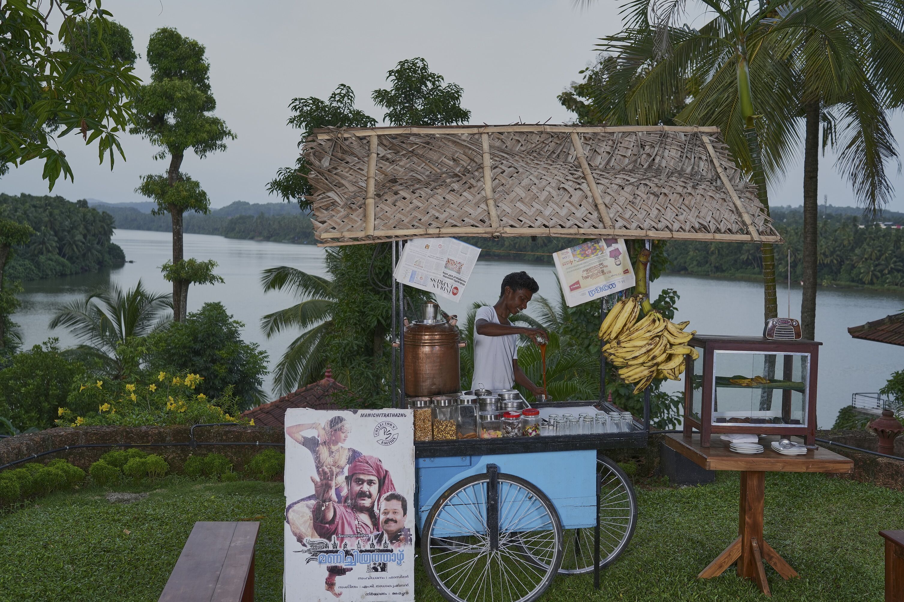 Un chariot de vente de nourriture avec un toit en bambou, un vélo et une affiche.