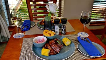 Una mesa de comedor con un plato de comida, una copa de vino blanco y una copa de vino tinto.