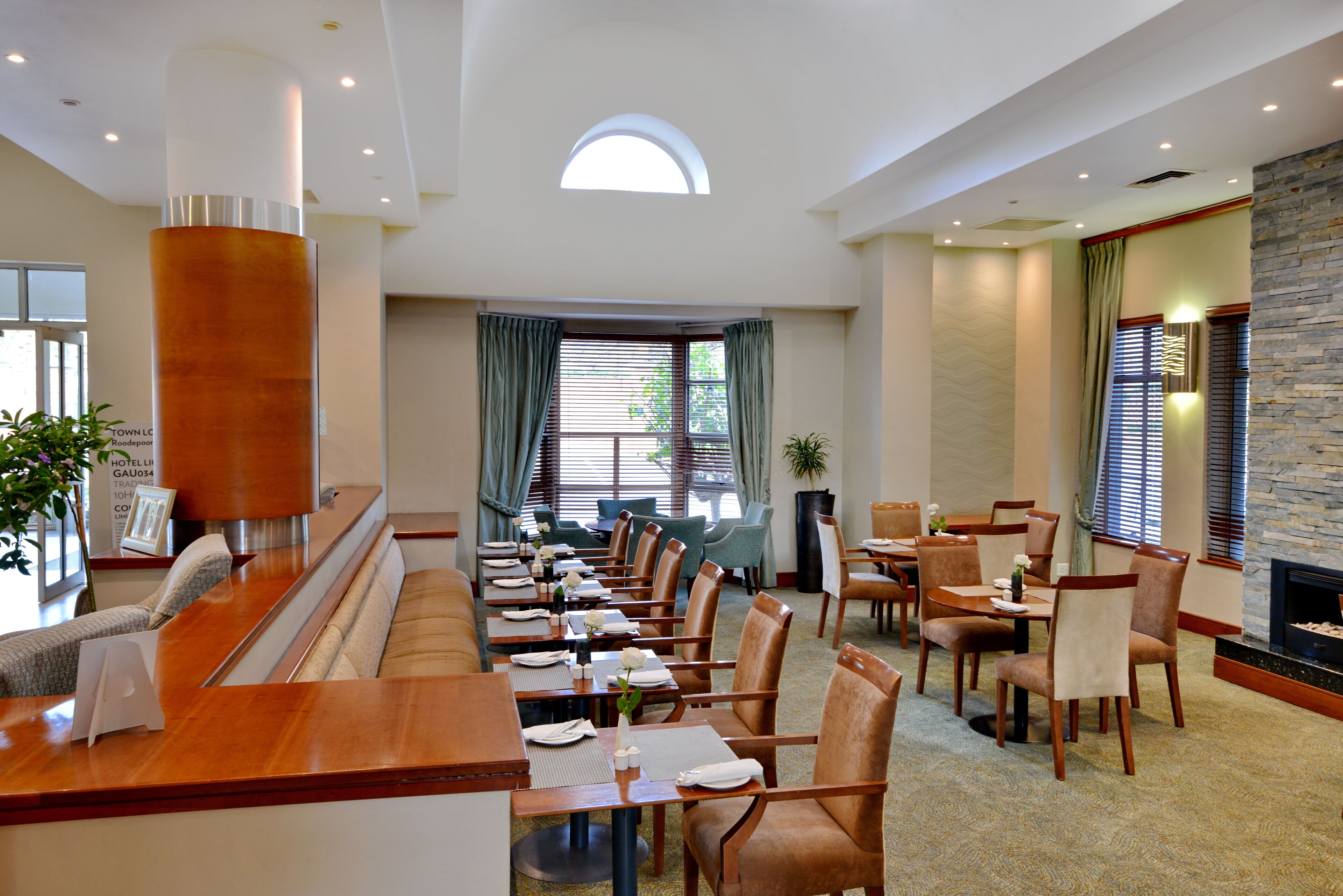 Un comedor de hotel con una larga barra, varias mesas y sillas.
