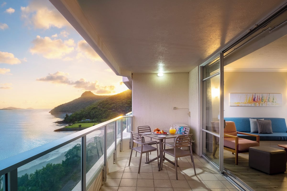 Ein Balkon mit Frühstückstisch, der einen malerischen Meerblick bietet.