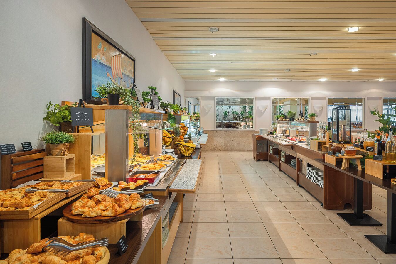 A buffet area with various food items and a sign welcoming guests to the sweet side.