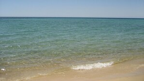 Een strand met helder water en een zandstrand.