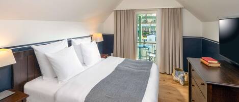 Habitación de hotel ordenada con cama, lámparas de noche, cómoda y televisor.