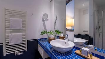 Une salle de bain avec deux lavabos, un porte-serviettes, un miroir et une douche.