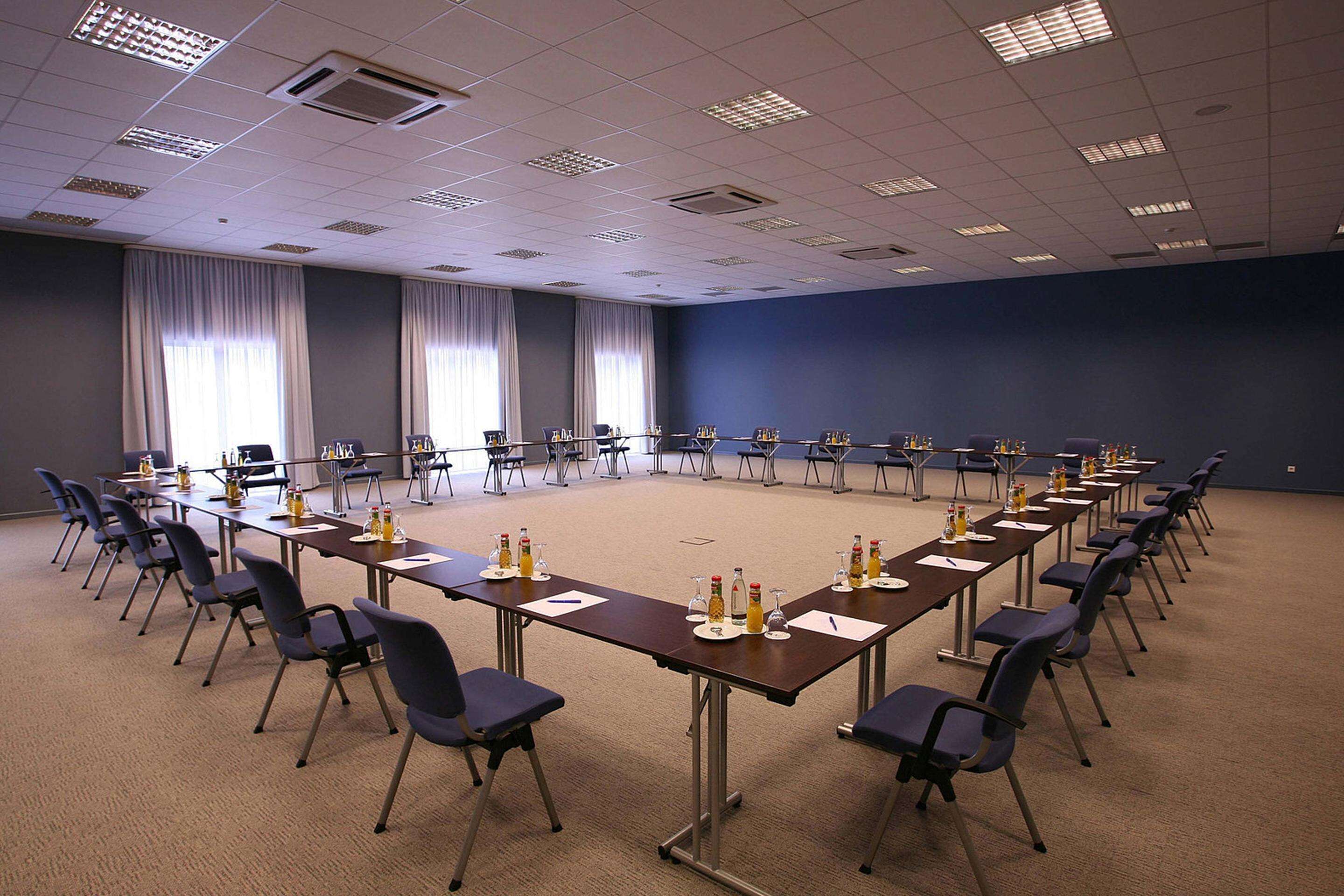 A conference room with a long table, chairs, and water bottles.