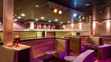 Un restaurant moderne avec des banquettes, un bar et un éclairage d’ambiance.
