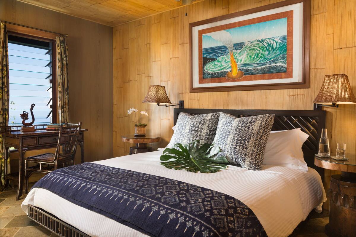 A neatly arranged bedroom with a large bed, a desk, and a chair.