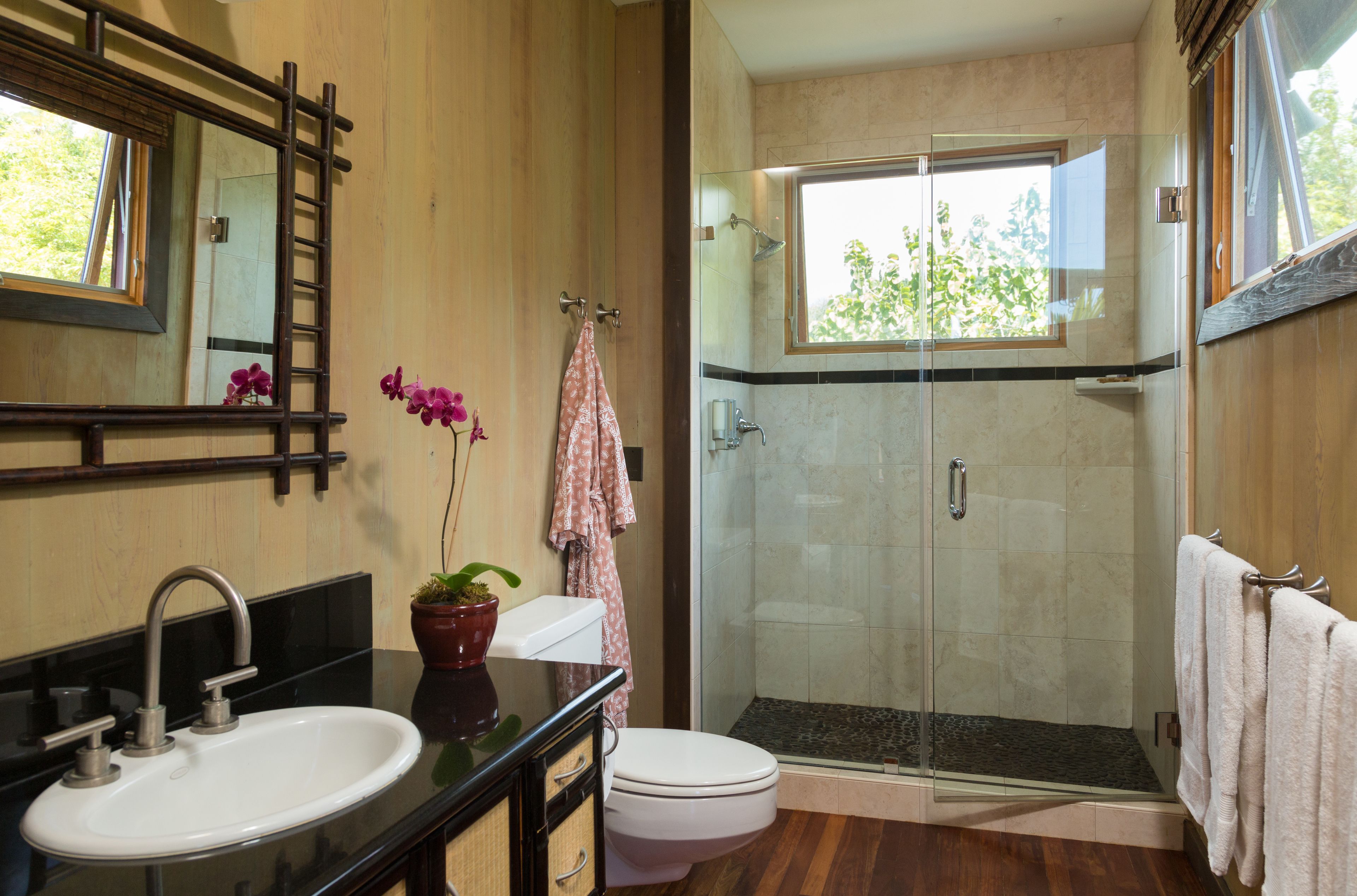 A bathroom with a sink, toilet, and glass-enclosed shower.
