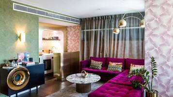 A modern living room with a vibrant purple sofa, a round coffee table, and a black console with a decorative item.