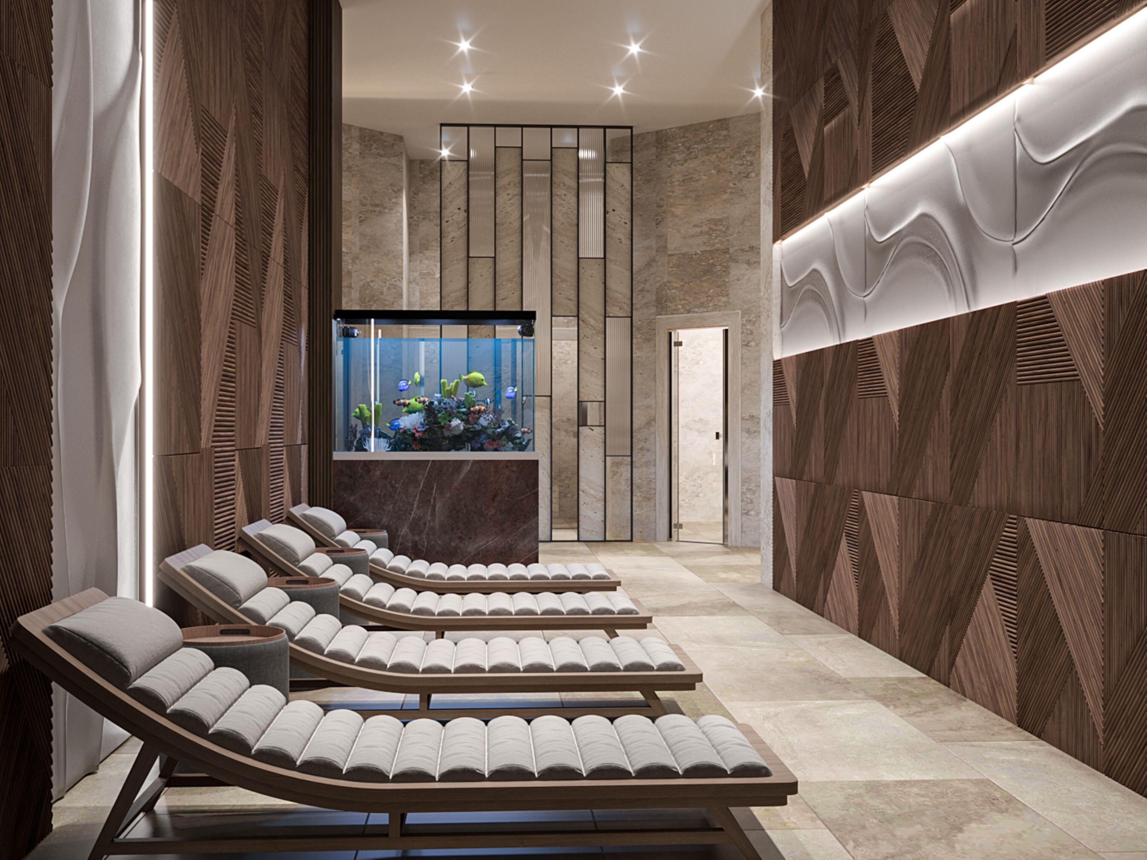 A modern spa area with reclining chairs, a large aquarium, and a wall with geometric patterns.