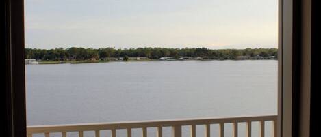 A balcony with a view of a lake and distant shoreline.