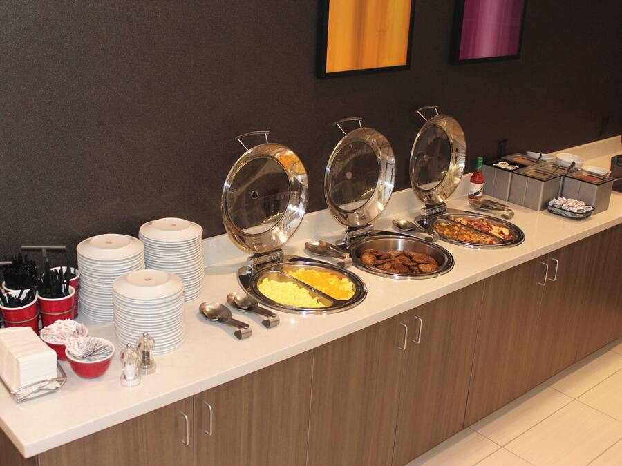 A buffet setup with various food items and utensils.