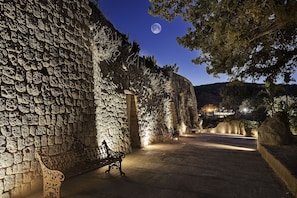 Un muro de piedra con un banco, un sendero pavimentado y vistas de la luna.