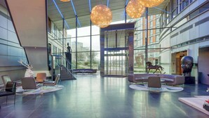 A spacious lobby with modern seating, large windows, and a sculpture of a horse. - Radisson Blu Hotel, London Canary Wharf East (London)
