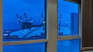 A hotel room with large windows overlooking a construction site with cranes and buildings. - Radisson Blu Hotel, London Canary Wharf East (London)