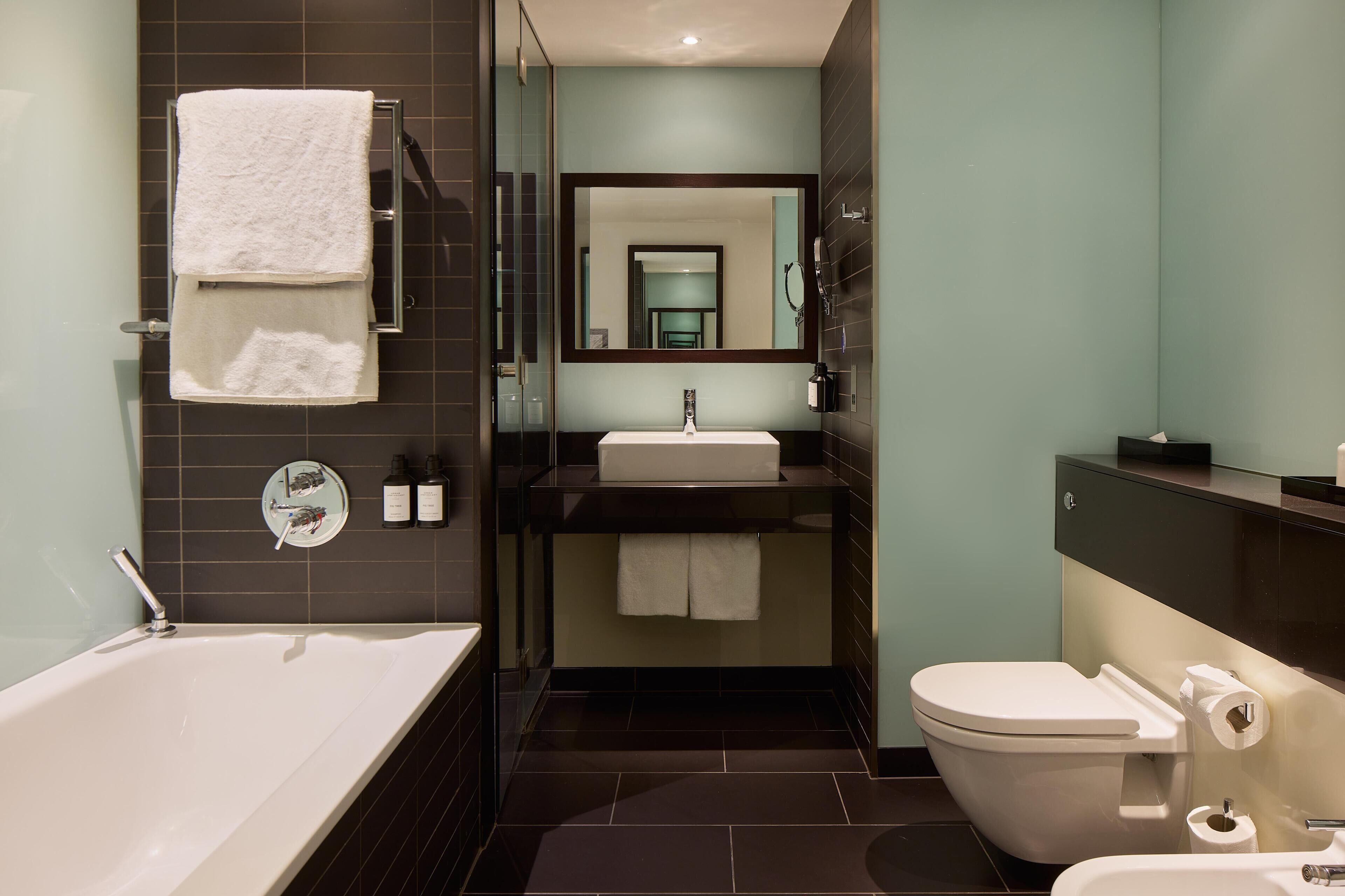 Ein modernes Badezimmer mit Badewanne, Waschbecken und Toilette.