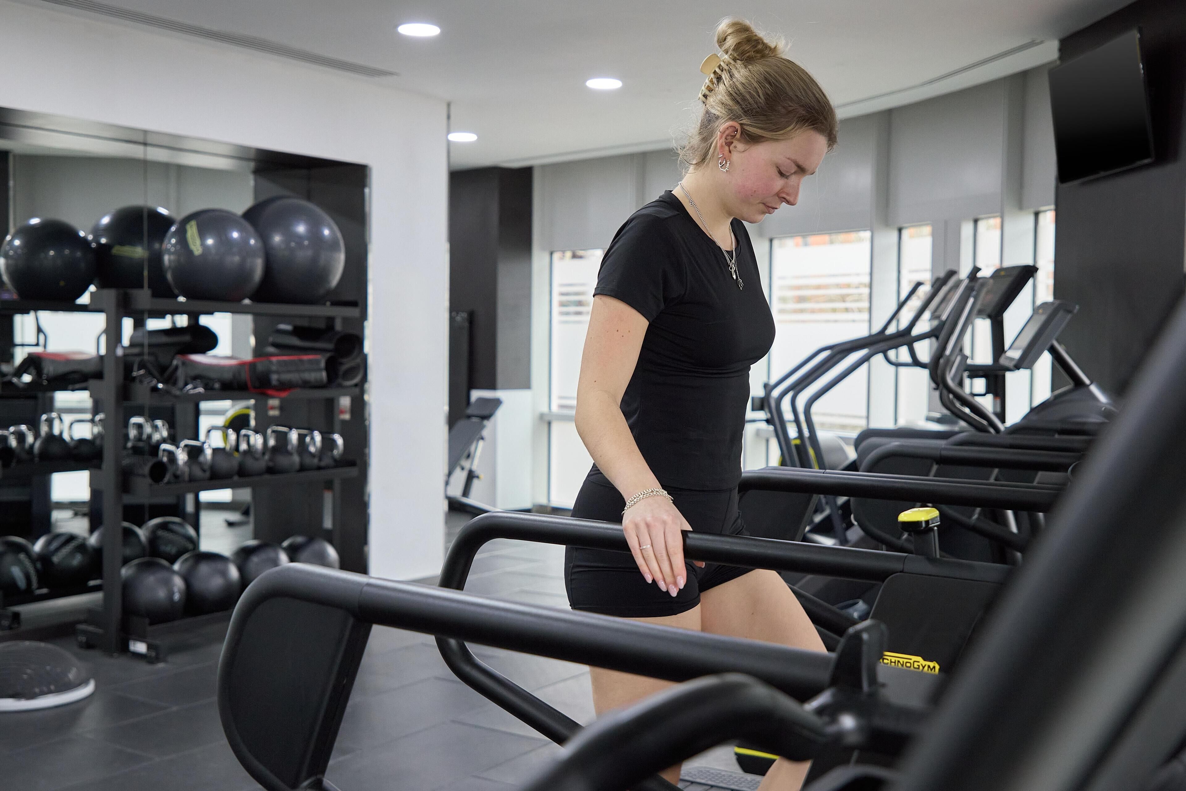 Ein Fitnessstudio mit Laufbändern, Kraftgeräten und verschiedenen Kurzhanteln.